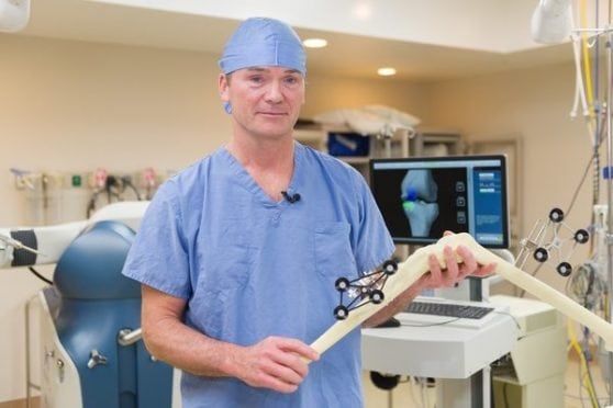 Hartford Hospital Dr. Christopher Lena with the robotic arm used in the MAKOplasty procedure.
