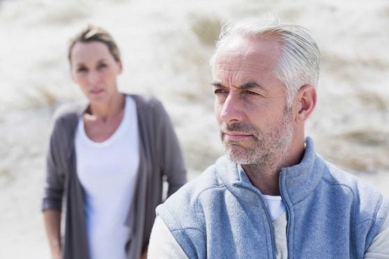 Serious-looking couple on beach.
