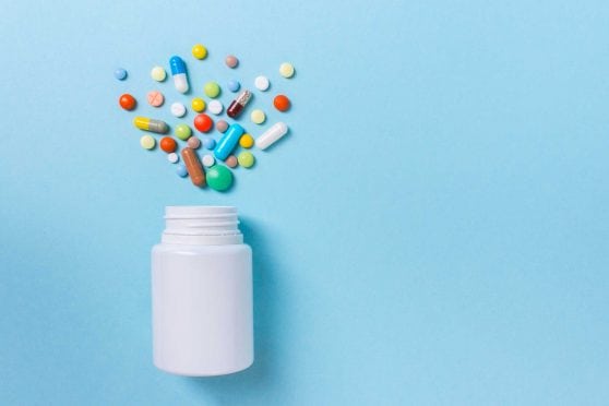 Pills popping out of bottle.