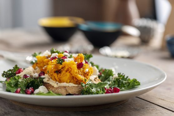 Butternut squash with kale,feta cheese,hummus and pomegranate on toast.