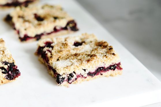 Honeysuckle crumble cake sliced into pieces on grey marble tray. Homemade streusel berries pie. Selective focus (Honeysuckle crumble cake sliced into pieces on grey marble tray. Homemade streusel berries pie. 