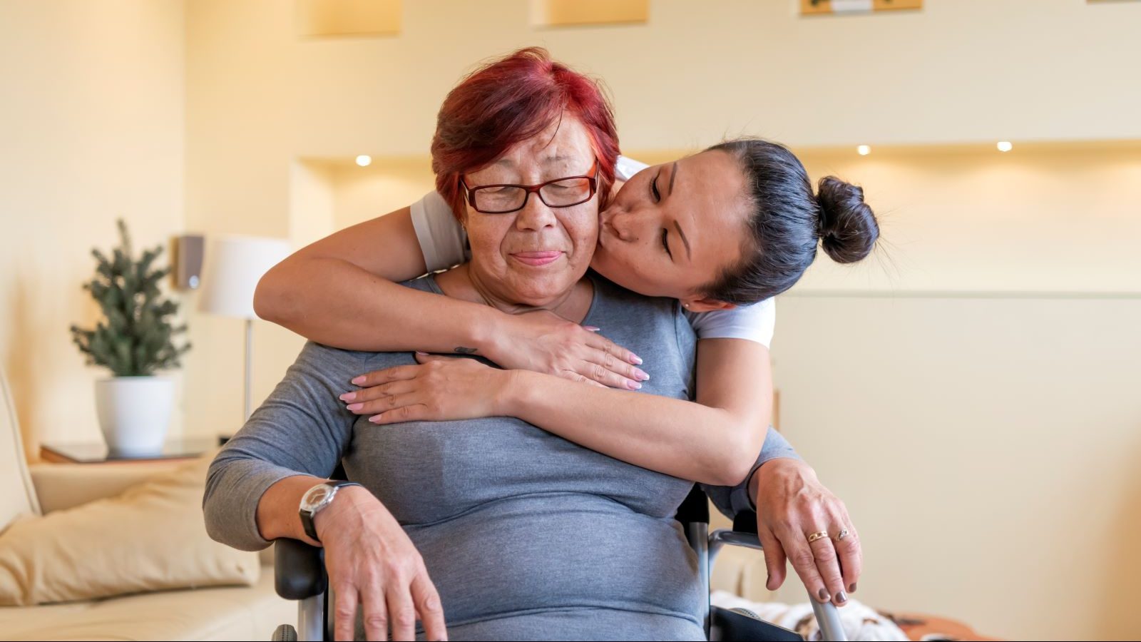 Caretaker hugs a woman with Alzheimer's.