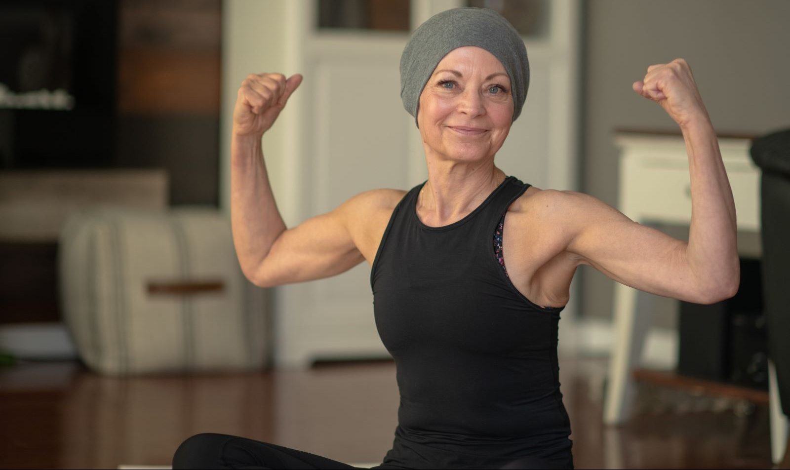 Cancer survivor flexes her muscles.