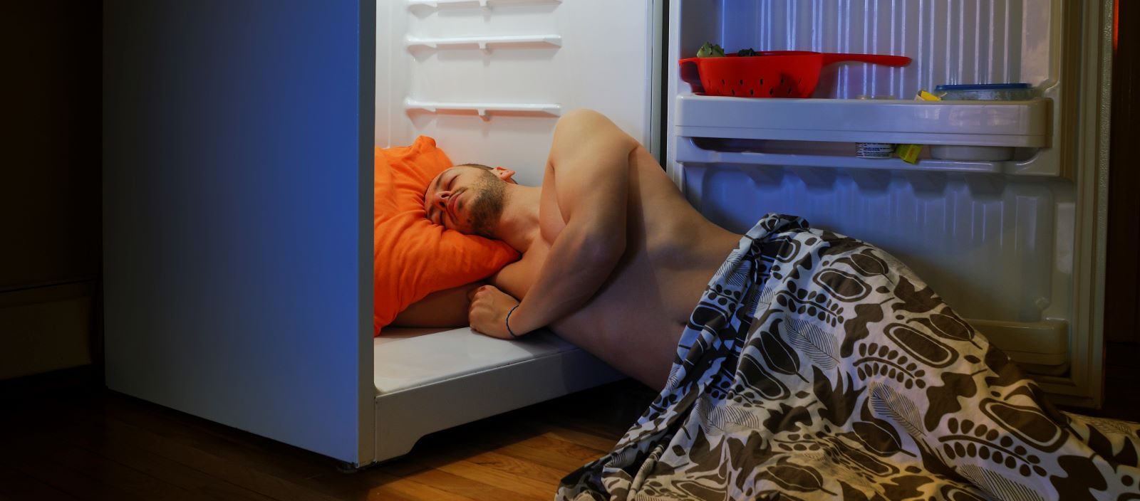 A man sleeps in the fridge to preserve sleep quality.