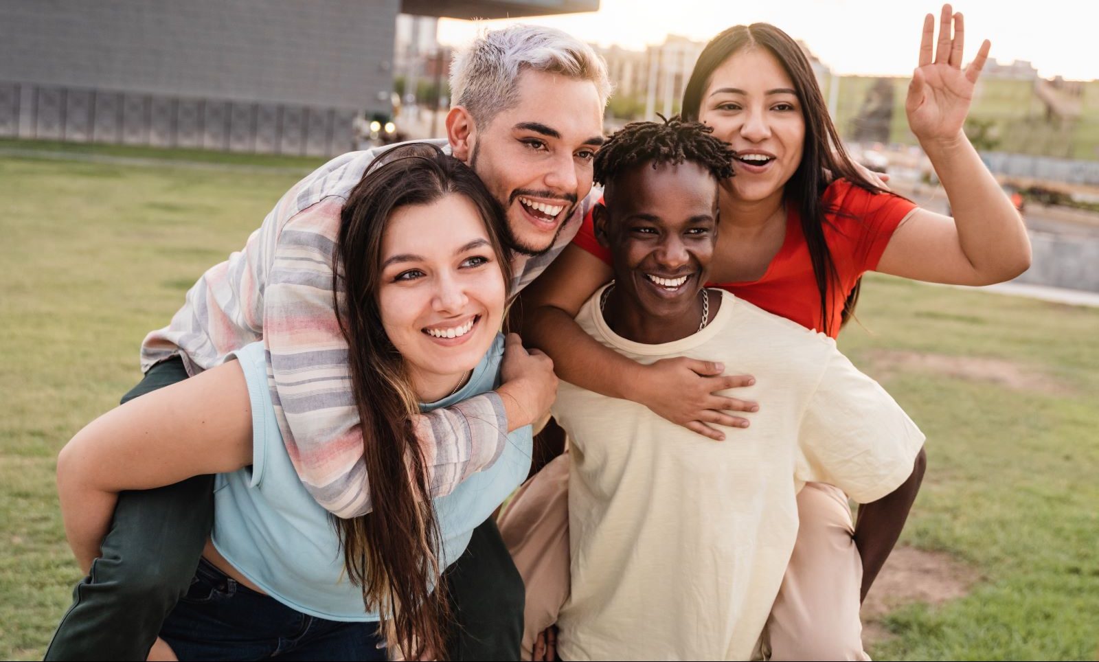 Four young LGBTQ+ people pose happily for a photo.