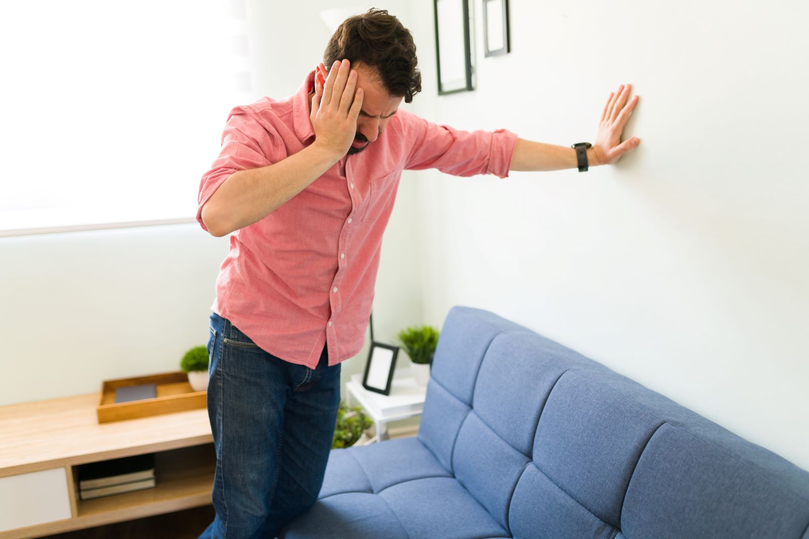 A person gets dizzy and leans against the wall.